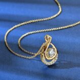 GLAMAVERA Elyenne Pendant 1CT moissanite infinity necklace in gold displayed on a blue background