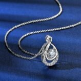 GLAMAVERA Elyenne Pendant 1CT moissanite infinity necklace in silver displayed on a blue background