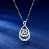 Vista frontale della collana GLAMAVERA Elyenne con ciondolo a forma di infinito in moissanite da 1 carato e argento su sfondo blu