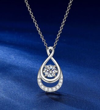 glamavera-elyenne-pendant-silver-front-view Front view of the GLAMAVERA Elyenne Pendant 1CT moissanite infinity necklace in silver on a blue background