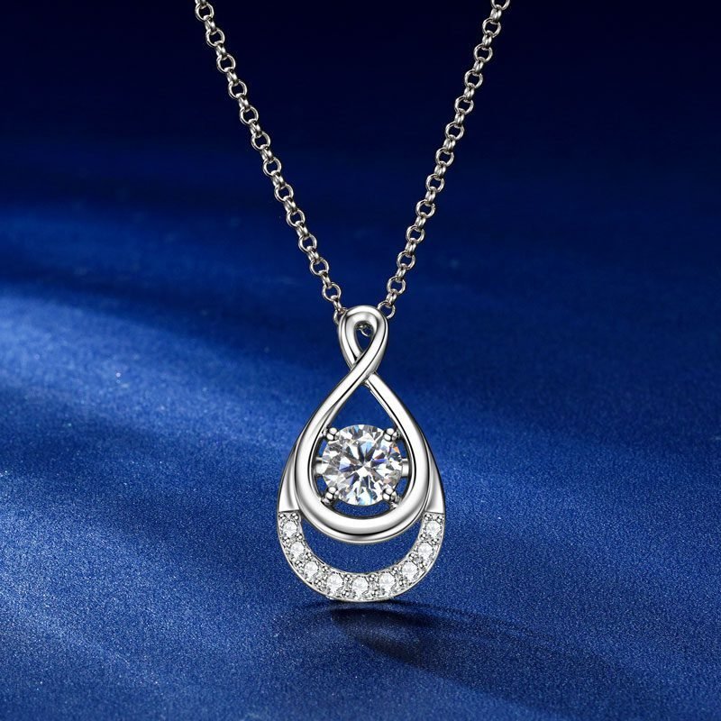 glamavera-elyenne-pendente-argento-vista-frontale Vista frontale della collana GLAMAVERA Elyenne con ciondolo a forma di infinito in moissanite da 1 carato e argento su sfondo blu