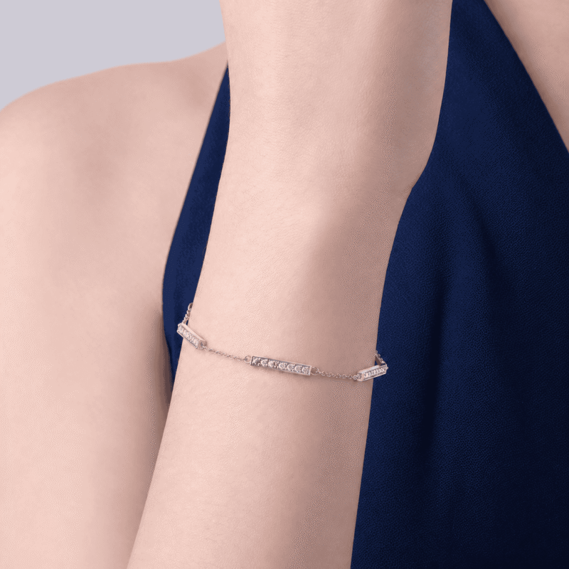 Bracelet GLAMAVERA « Halvane » à maillons en moissanite, en argent sterling 925, porté au poignet avec une manche bleu marine