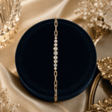 GLAMAVERA Kessane gold-plated moissanite tennis bracelet displayed on a navy velvet jewellery stand