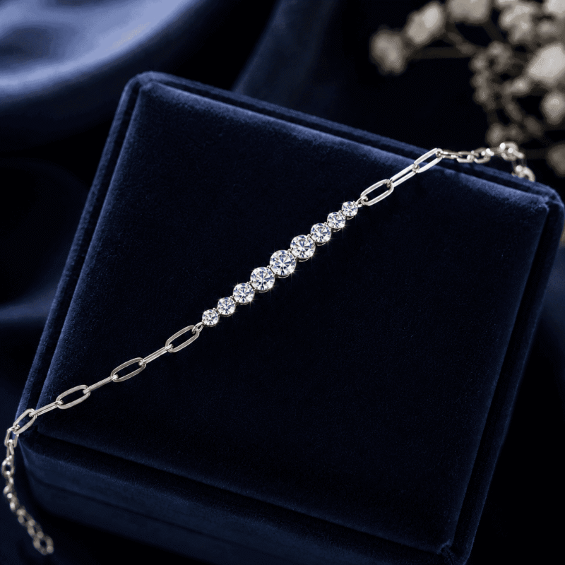 GLAMAVERA Kessane silver moissanite tennis bracelet displayed on a navy velvet jewellery box