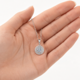 Silver Lyrane Halo Pendant Necklace by GLAMAVERA displayed in a woman’s hand to show the pendant size
