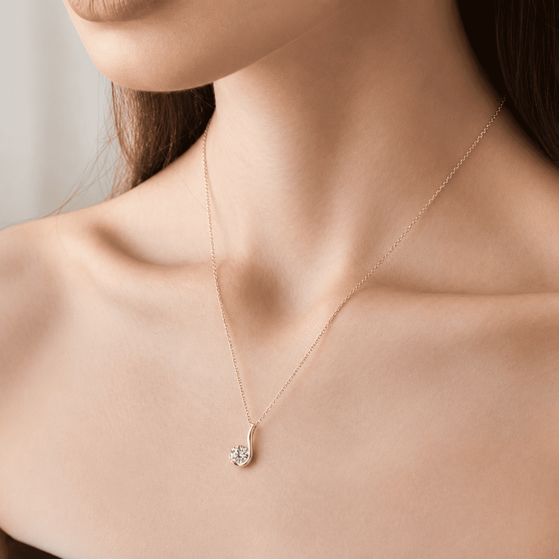 Gold GLAMAVERA Nerine Pendant 1CT Moissanite Curl Necklace worn around a woman’s neck.