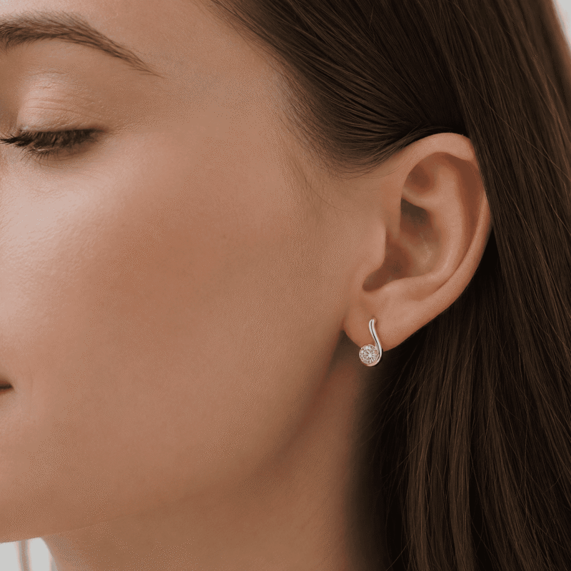 glamavera-nerine-studs-gold-on-ear GLAMAVERA Nerine Studs gold-tone moissanite curl earring worn on the ear