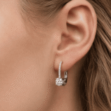 Macro close-up of a Rivane Drops silver moissanite leverback earring worn on the ear