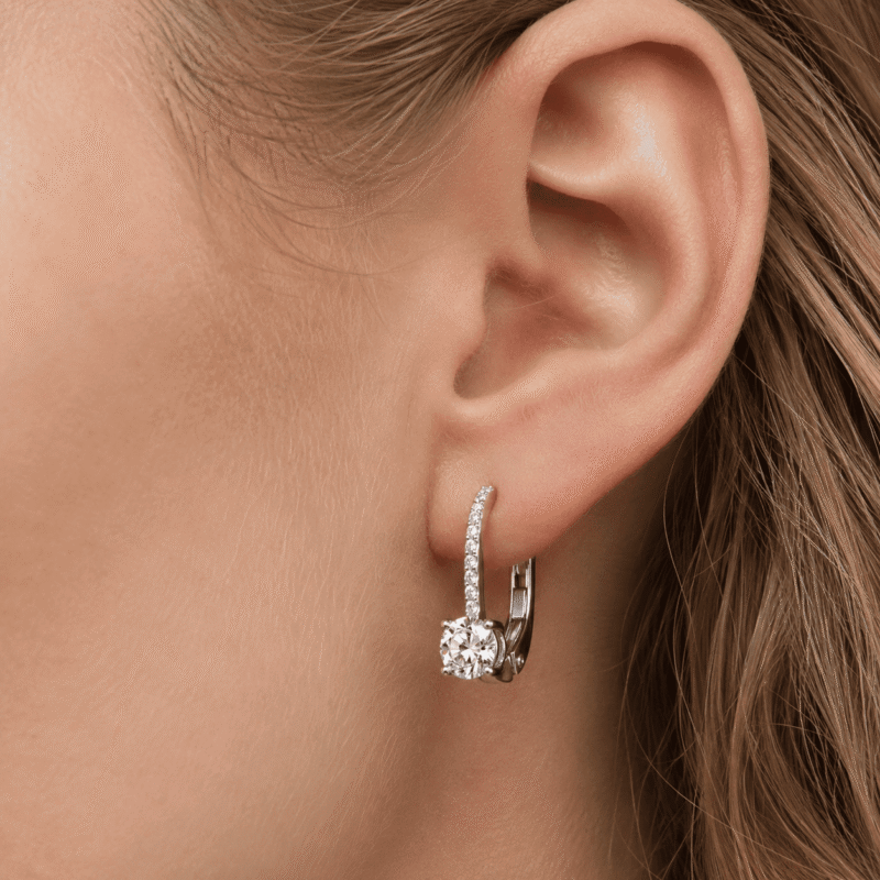 rivane-drops-silver-moissanite-earrings-macro-on-ear Macro close-up of a Rivane Drops silver moissanite leverback earring worn on the ear