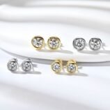 Gold-tone and silver Torvane moissanite stud earrings displayed on a white jewellery surface