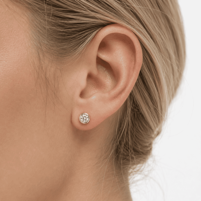 torvane-studs-gold-tone-moissanite-earring-on-ear Torvane gold-tone moissanite bubble stud earring worn on the ear